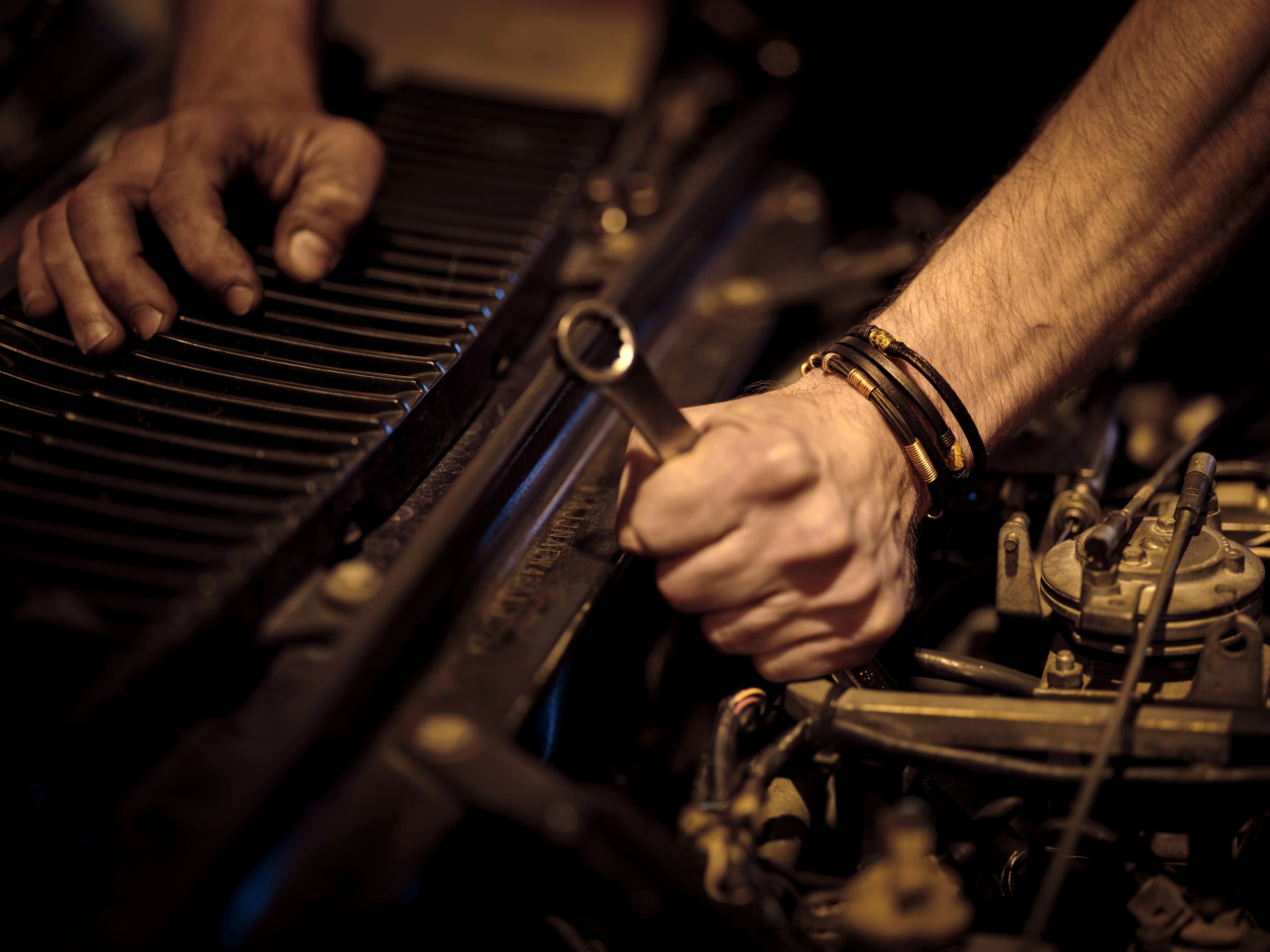 Workshop mechanic comparing OEM, OES and aftermarket car spare parts